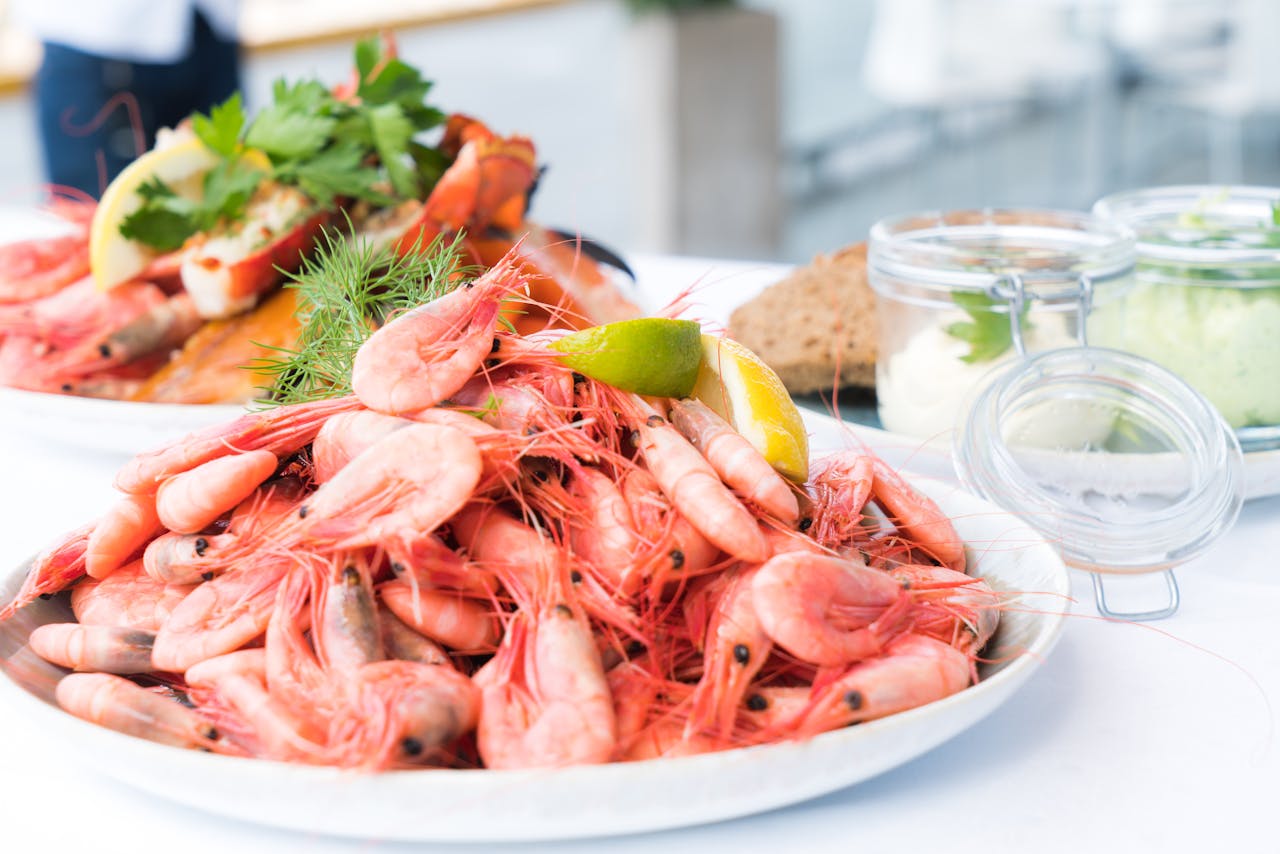 about-us Plate of shrimp and seafood garnished with lemon and herbs, perfect for a gourmet meal.